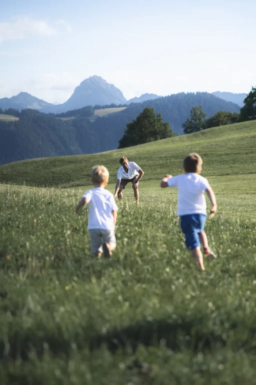 Enfants d'une famille qui court dans un pré lors d'une séance photo de famille. Photo du photographe Rüdi Welter. Enfants d'une famille qui court dans un pré lors d'une séance photo de famille. Photo du photographe Rüdi Welter.