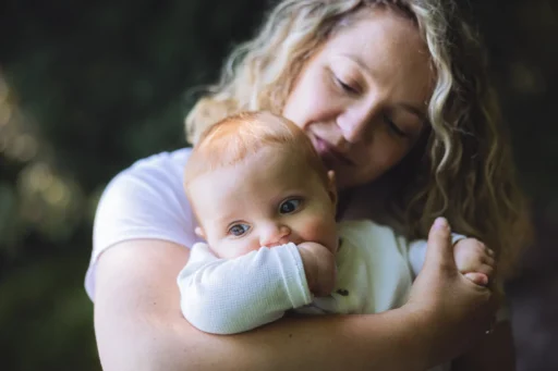 Bébé dans les bras de sa mère lors d'une séance photo de famille à Yvoire. Photo du photographe Rüdi Welter. Bébé dans les bras de sa mère lors d'une séance photo de famille à Yvoire. Photo du photographe Rüdi Welter.